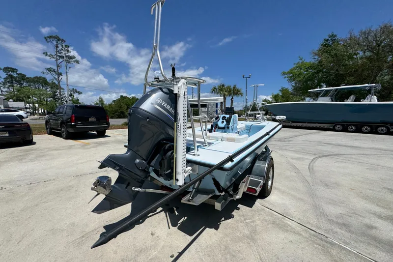 Slide: The Image of 2016 Hell's Bay Marquesa boat with Yamaha engine on trailer in sunny outdoor setting. - 12
