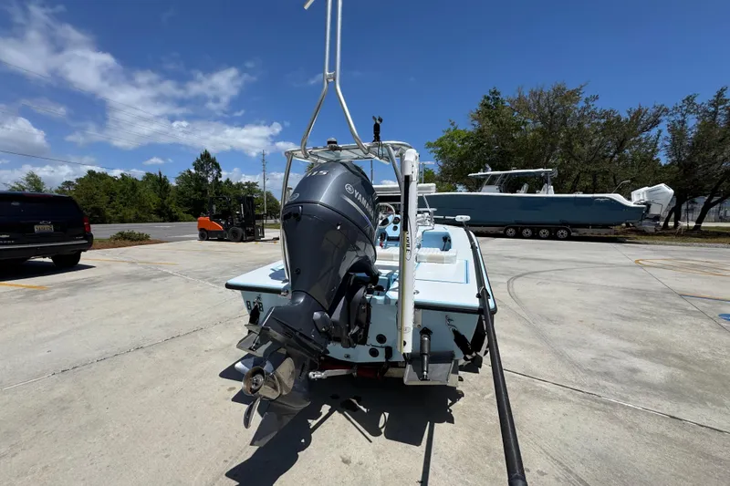 Slide: The Image of 2016 Hell's Bay Marquesa boat with Yamaha outboard motor in a sunny parking lot. - 13