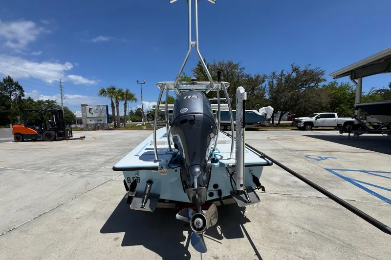 Slide: The Image of 2016 Hell's Bay Marquesa boat with outboard motor in a sunny parking lot. - 14