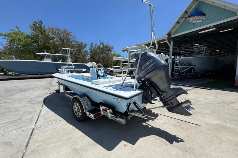 Slide: The Image of 2016 Hell's Bay Marquesa boat with Yamaha engine on trailer, parked outside a boatyard. - 16