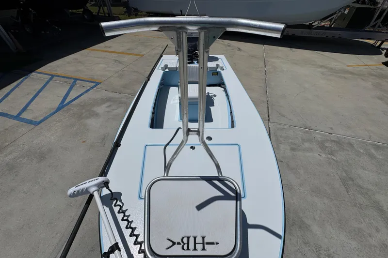 Slide: The Image of 2016 Hell's Bay Marquesa boat on concrete, featuring a sleek deck and steering console. - 23