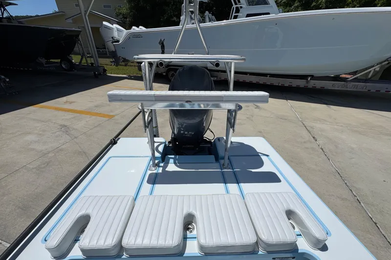 Slide: The Image of 2016 Hell's Bay Marquesa boat with cushioned seating and motor, parked on concrete. - 32