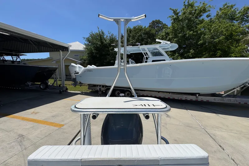 Slide: The Image of 2016 Hell's Bay Marquesa boat parked outdoors near other vessels. - 35