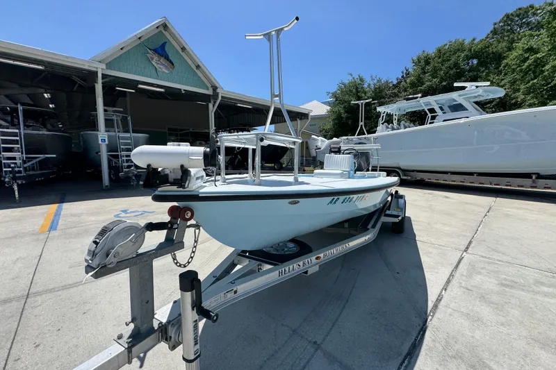 Slide: The Image of 2016 Hell's Bay Marquesa boat on trailer at marina under clear blue sky. - 4