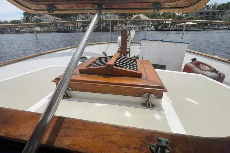 Slide: The Image of 1979 Albin 36 Trawler deck view with wooden hatch and marina background. - 11