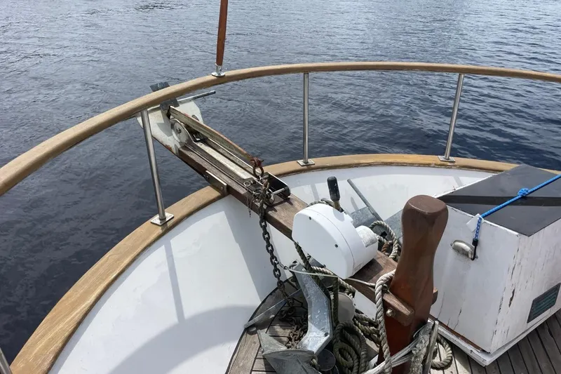 Slide: The Image of Bow of 1979 Albin 36 Trawler with anchor and winch, on calm water. - 15