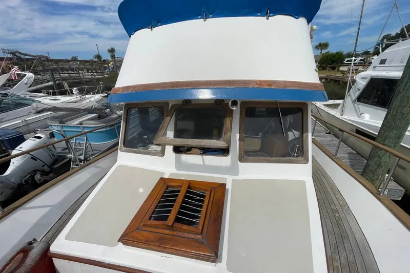 Slide: The Image of 1979 Albin 36 Trawler with blue canopy, docked at marina. - 3