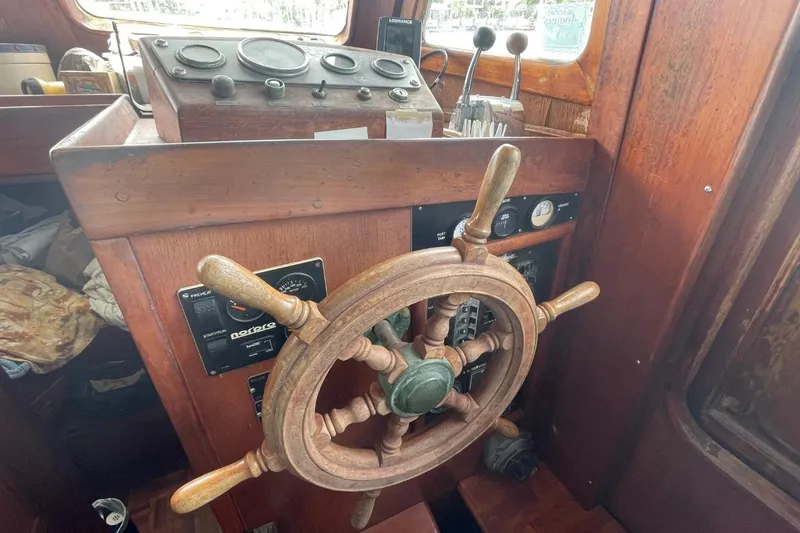 Slide: The Image of Wooden helm of a 1979 Albin 36 Trawler, featuring classic nautical controls. - 6
