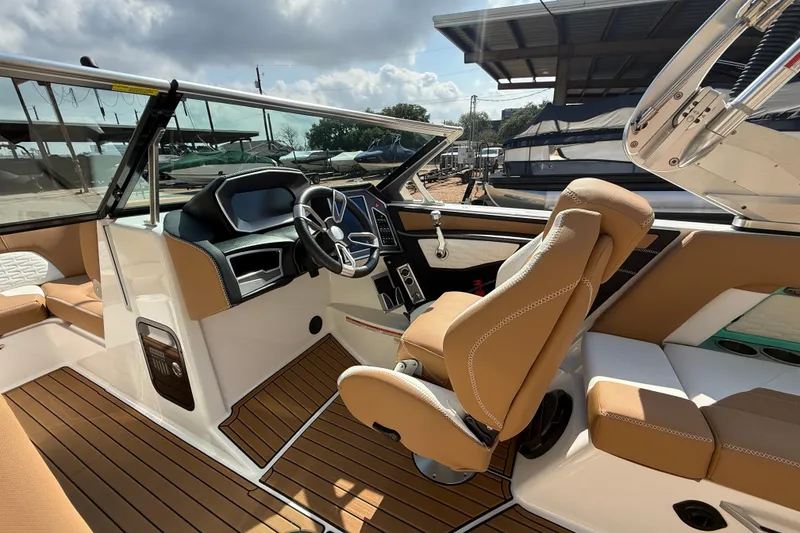 Slide: The Image of 2020 MasterCraft X22 boat interior with tan seating and modern dashboard. - 10