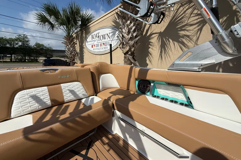 Slide: The Image of 2020 MasterCraft X22 boat interior with tan and white seating at Boat Town dealership. - 16