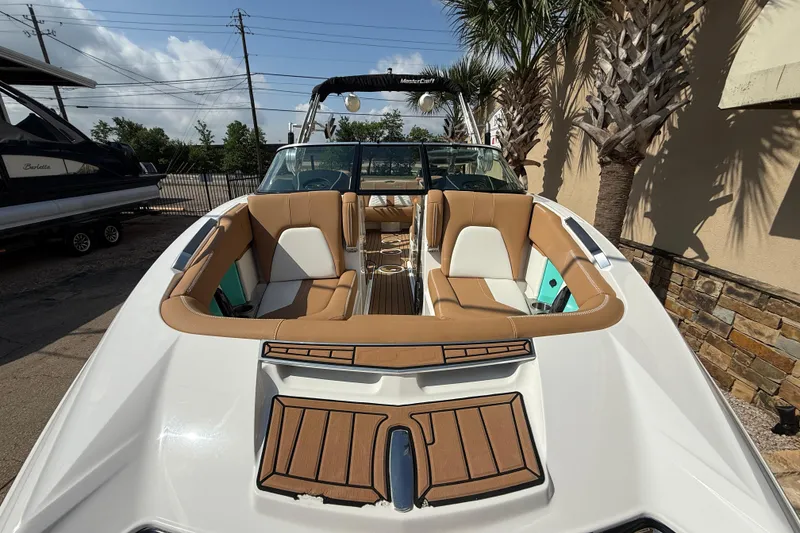 Slide: The Image of 2020 MasterCraft X22 boat with tan seating and sleek design, docked outdoors. - 3