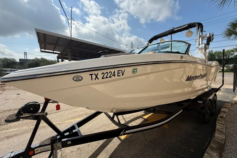 Slide: The Image of 2020 MasterCraft X22 boat on trailer under sunny sky. - 4
