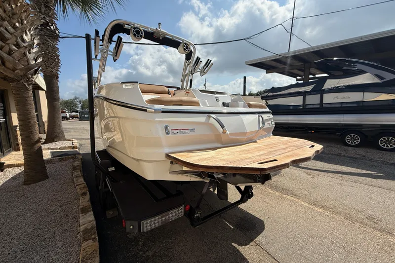 Slide: The Image of 2020 MasterCraft X22 boat on trailer, parked outdoors under a partly cloudy sky. - 5