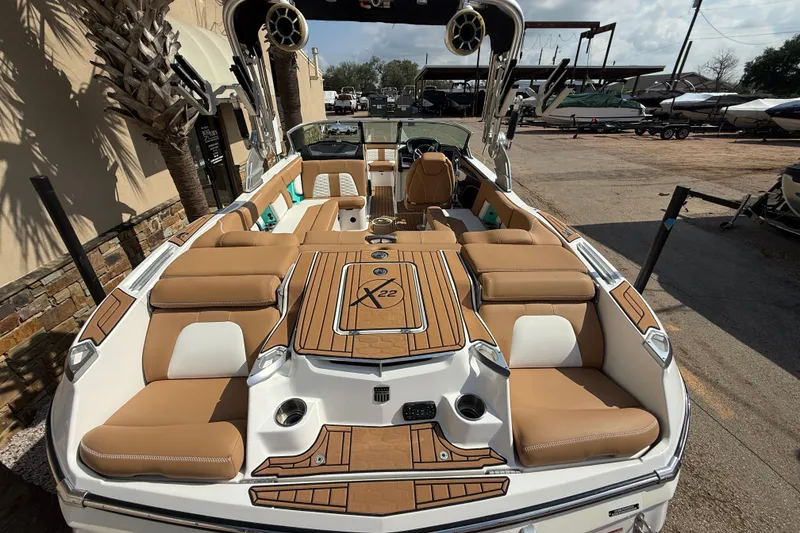 Slide: The Image of 2020 MasterCraft X22 boat with tan seating and sleek design, parked outdoors. - 8