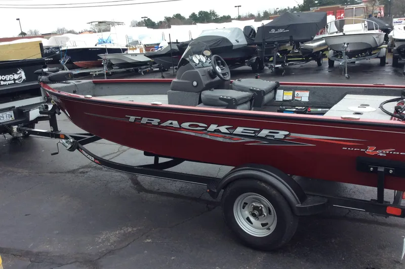 The Image of 2021 Tracker Super Guide V-16 SC boat on trailer in dealership lot. - 0