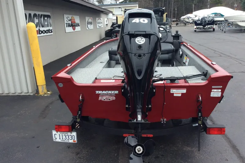 Slide: The Image of 2021 Tracker Super Guide V-16 SC boat with Mercury 40 engine, parked outside dealership. - 2