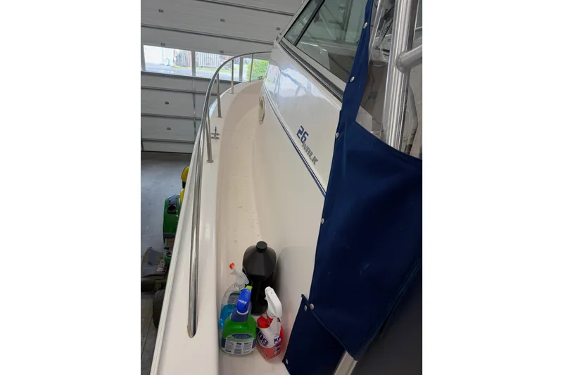Slide: The Image of 2002 Pro-Line 260 Walkaround boat in garage with cleaning supplies on deck. - 11