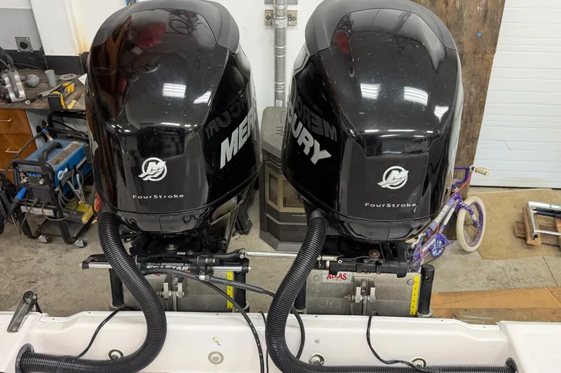 Slide: The Image of Twin Mercury FourStroke engines on a 2002 Pro-Line 260 Walkaround boat in a workshop. - 16