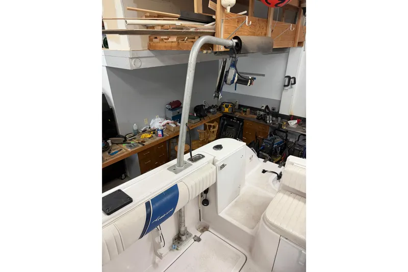 Slide: The Image of 2002 Pro-Line 260 Walkaround boat interior with fishing rod holder in a workshop setting. - 18