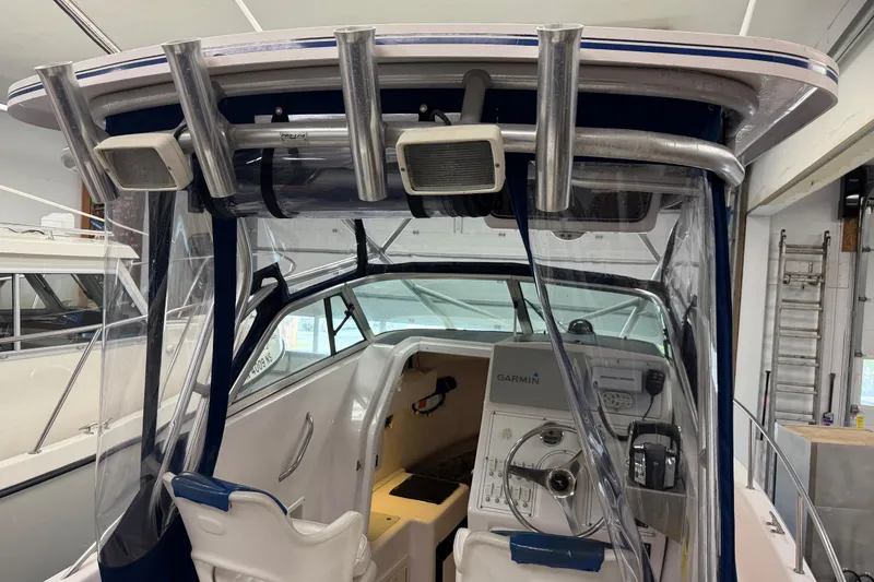 Slide: The Image of 2002 Pro-Line 260 Walkaround boat interior with helm, Garmin electronics, and rod holders. - 24