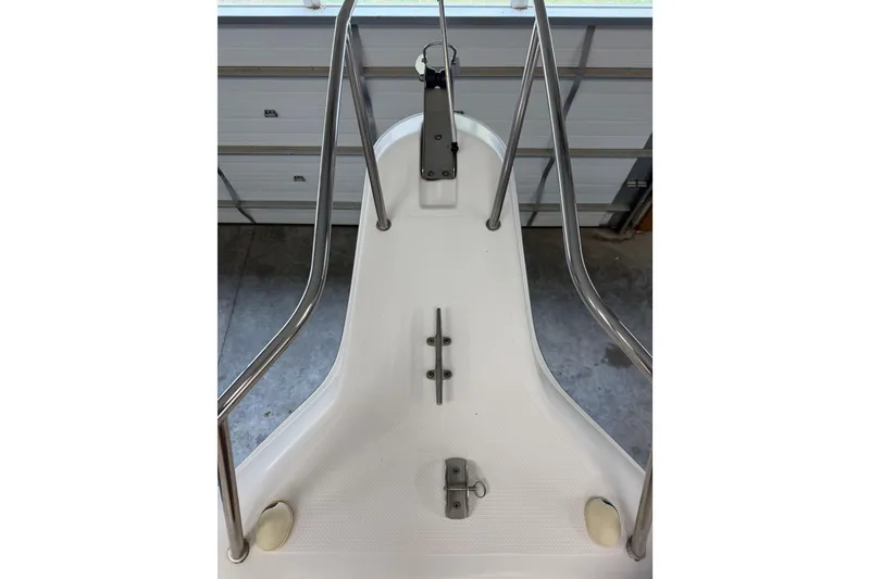 Slide: The Image of 2002 Pro-Line 260 Walkaround boat bow with stainless steel railings in a garage setting. - 26