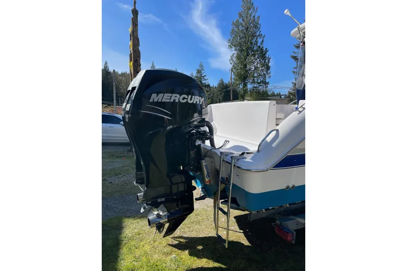 Slide: The Image of 2002 Pro-Line 260 Walkaround boat with Mercury outboard motor, parked outdoors. - 3