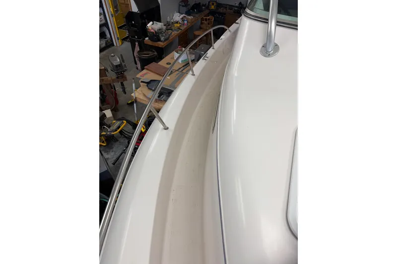 Slide: The Image of 2002 Pro-Line 260 Walkaround boat deck with railing in a workshop setting. - 30