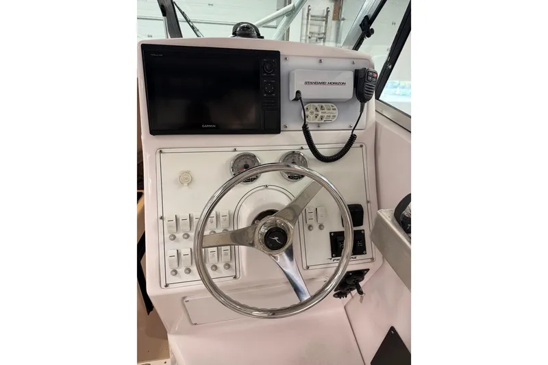 Slide: The Image of 2002 Pro-Line 260 Walkaround boat dashboard with steering wheel and navigation equipment. - 33