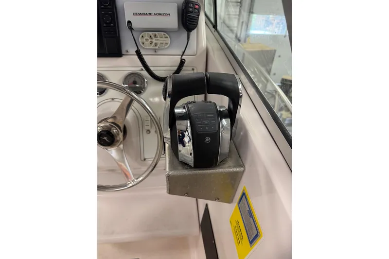 Slide: The Image of Control panel of a 2002 Pro-Line 260 Walkaround boat with steering wheel and throttle. - 34