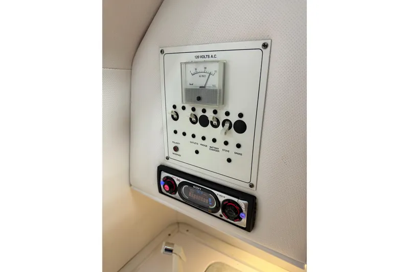 Slide: The Image of Control panel of a 2002 Pro-Line 260 Walkaround boat, featuring voltage meter and stereo system. - 38