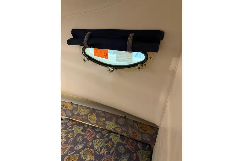 Slide: The Image of Interior of 2002 Pro-Line 260 Walkaround boat with porthole and patterned seating. - 41
