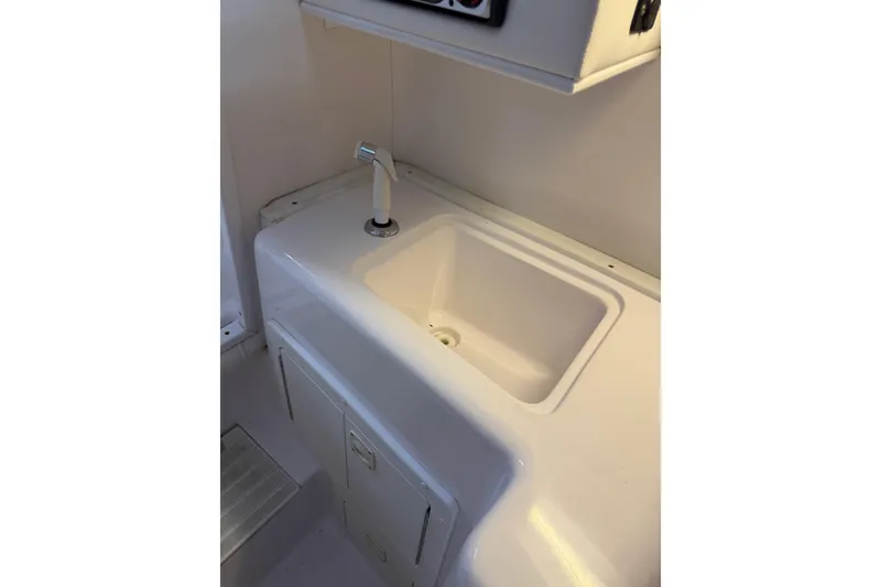 Slide: The Image of 2002 Pro-Line 260 Walkaround boat sink with faucet in cabin area. - 44