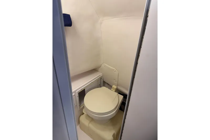 Slide: The Image of 2002 Pro-Line 260 Walkaround boat interior bathroom with compact toilet. - 48
