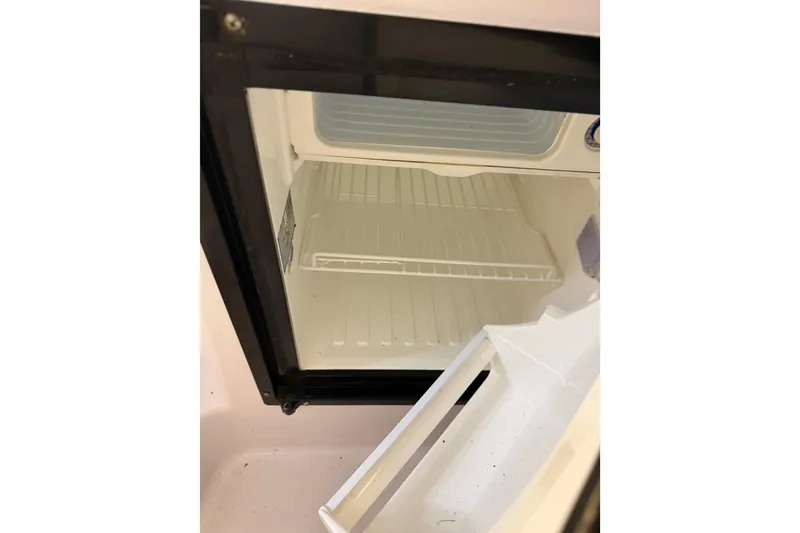Slide: The Image of Empty refrigerator inside a 2002 Pro-Line 260 Walkaround boat. - 50