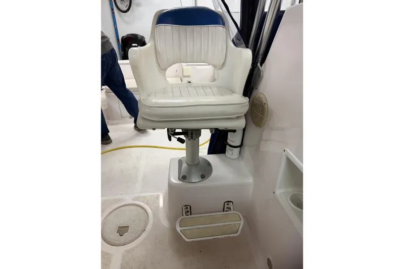 Slide: The Image of Captain's chair on 2002 Pro-Line 260 Walkaround boat, featuring white upholstery and pedestal mount. - 56