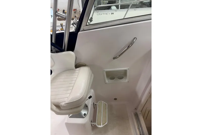 Slide: The Image of 2002 Pro-Line 260 Walkaround boat interior with white seating and cup holders. - 57