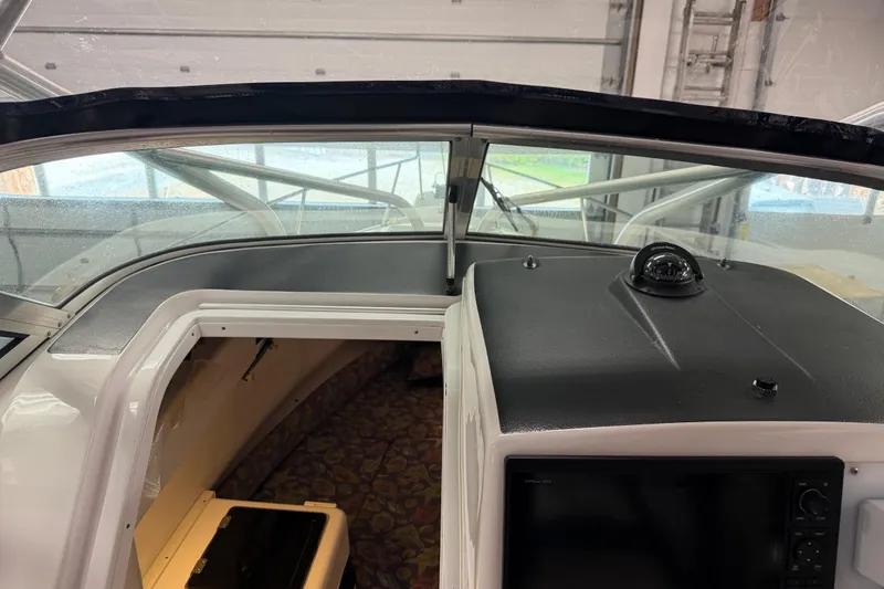 Slide: The Image of 2002 Pro-Line 260 Walkaround boat interior with dashboard and cabin view. - 58