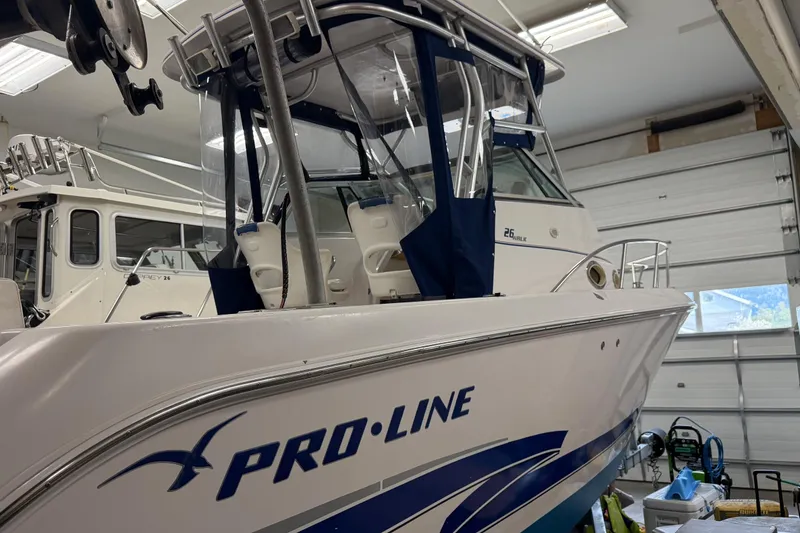 Slide: The Image of 2002 Pro-Line 260 Walkaround boat in a garage, showcasing sleek design and sturdy build. - 6