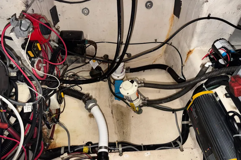 Slide: The Image of Engine compartment of a 2002 Pro-Line 260 Walkaround boat, showcasing wiring and mechanical components. - 65