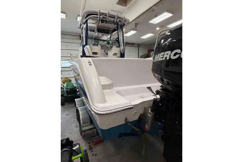 Slide: The Image of 2002 Pro-Line 260 Walkaround boat in garage, featuring a powerful Mercury outboard engine. - 8
