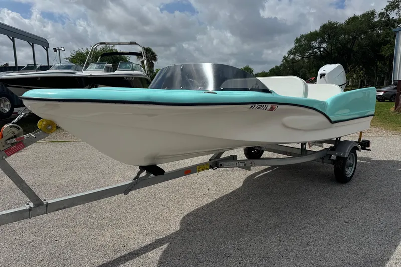 Slide: The Image of 1959 Redfish 14 Shark boat with turquoise accents on a trailer. - 3