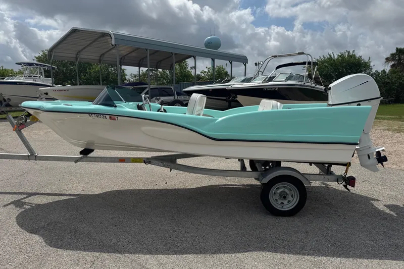 Slide: The Image of 1959 Redfish 14 Shark boat on trailer, light blue and white, parked outdoors. - 4
