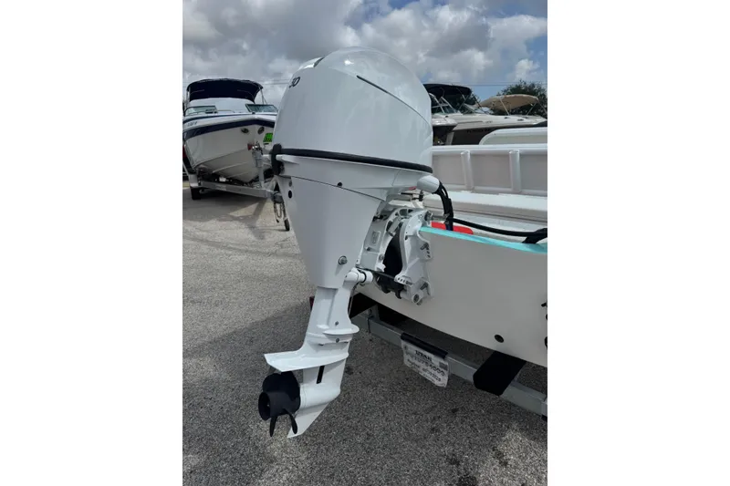 Slide: The Image of White outboard motor on a Redfish 14 Shark boat, 1959 model, parked on a trailer. - 5