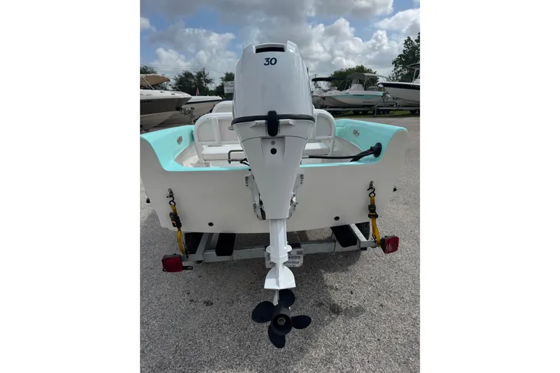 Slide: The Image of 1959 Redfish 14 Shark boat with outboard motor on trailer, under cloudy sky. - 6