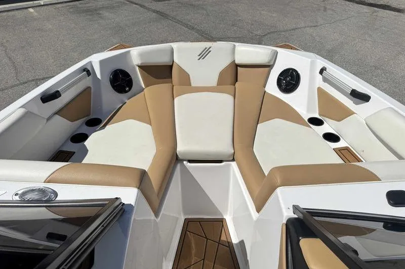 Slide: The Image of 2021 ATX Type 22s boat interior with tan and white seating, cup holders, and speakers. - 16