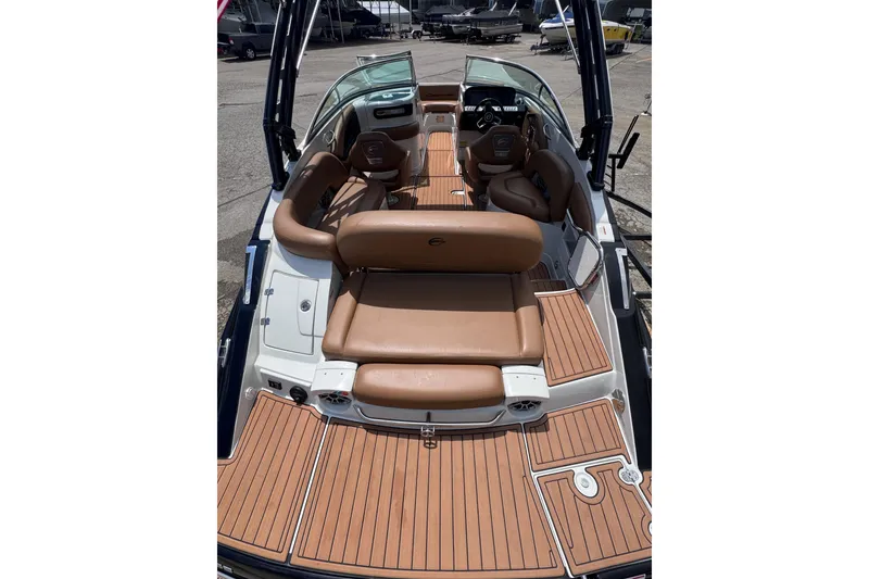 Slide: The Image of 2025 Crownline Eclipse E235 boat interior with tan seating and wood-style flooring. - 11
