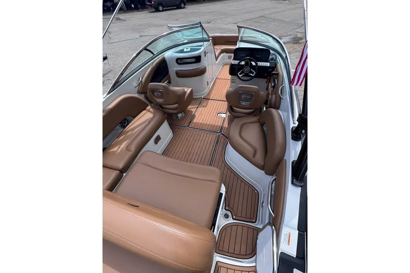 Slide: The Image of 2025 Crownline Eclipse E235 boat interior with tan leather seating and wood-style flooring. - 13