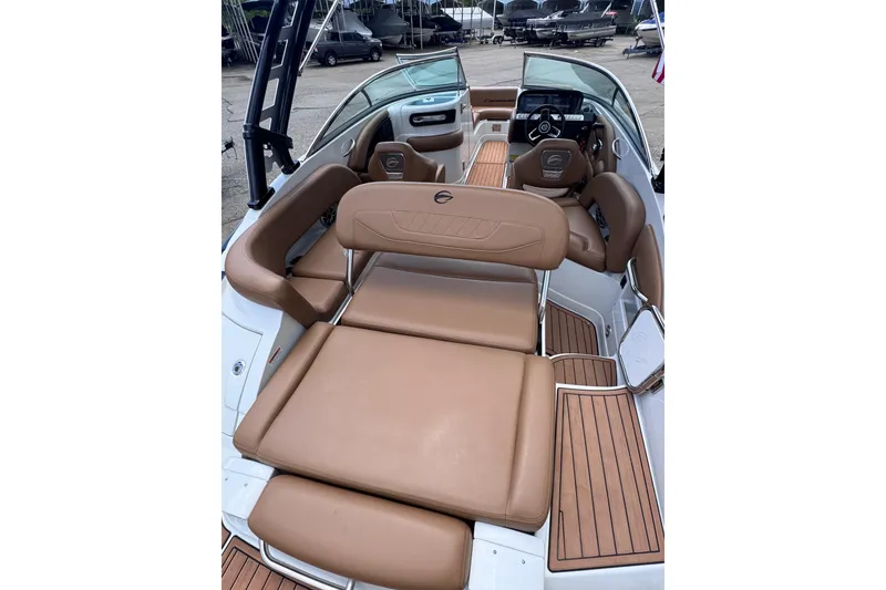 Slide: The Image of 2025 Crownline Eclipse E235 boat interior with tan seating and wood accents. - 15