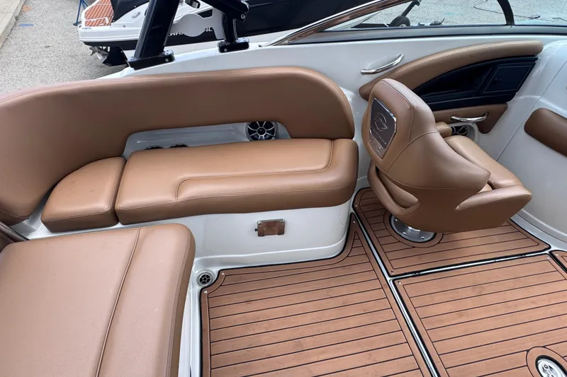 Slide: The Image of 2025 Crownline Eclipse E235 boat interior with tan leather seating and wood-style flooring. - 16