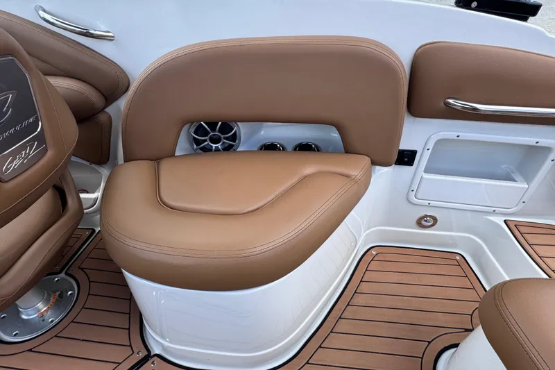 Slide: The Image of 2025 Crownline Eclipse E235 boat interior with tan seating and wood-style flooring. - 18